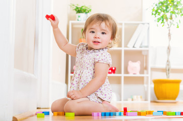 Toddler girl playing with her toy blocks