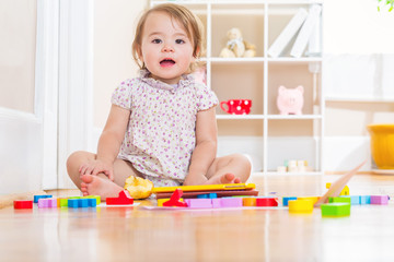 Happy toddler smiling and playing with toy blocks