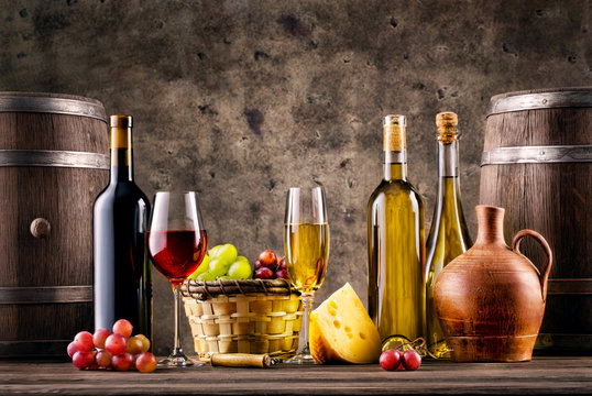 Still life with wine, grapes, barrels and cheese