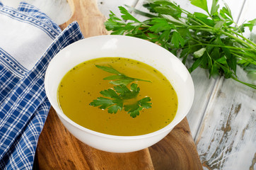 Bowl of broth on wooden table.