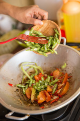 A portrait of process adding bean into stir-fry tomato and veget