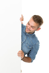 Young man standing  next to a blank white billboard