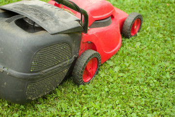 Fototapeta na wymiar red lawnmower on green grass