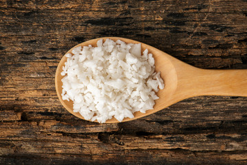 Salt on wooden spoon put on table