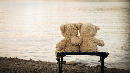2 embracing teddybears sitting overlooking the lake and mountains