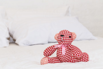 Red bear doll on bed
