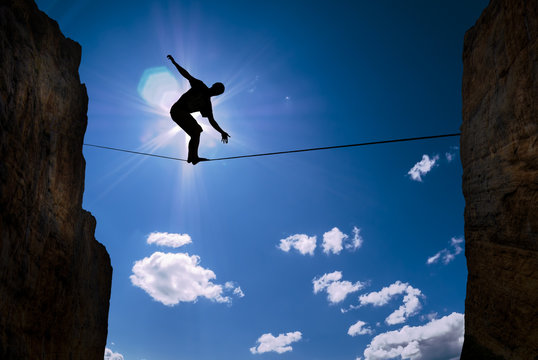 Concept of risk taking man balancing on the rope
