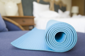 A yoga mat in a bedroom, exercising in bedroom