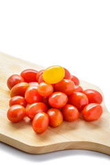 pile of cherry tomatoes on a wooden cutting board