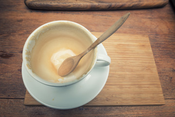 Empty coffee cup after drink with spoon on wood table. Filter : Vintage effected.