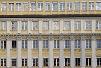 Fototapeta na wymiar Yellow facade with rows of windows in typical german architecture style building. Munich,Bavaria,Germany.
