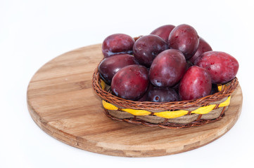 Fresh plums in the wooden basket