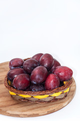 Fresh plums in the wooden basket