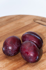 Close view of fresh plums on the wooden board