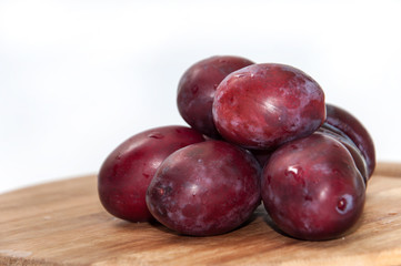 Fresh cleaned plums on the kitchen wooden board