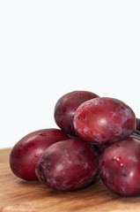 Fresh cleaned plums on the kitchen wooden board