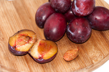 Opened plums on the wooden board