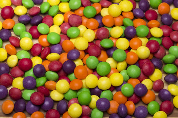 Fototapeta na wymiar Chocolate candy buttons. A pile of colorful button-shaped chocolates.
