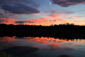 Oranger Himmel beim Sonnenuntergang spiegelt sich im Wasser