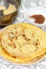 Yellow fresh pancakes served on the plate with cocoa sugar