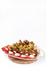 Fried zucchini with bacon and olives arranged on the plate