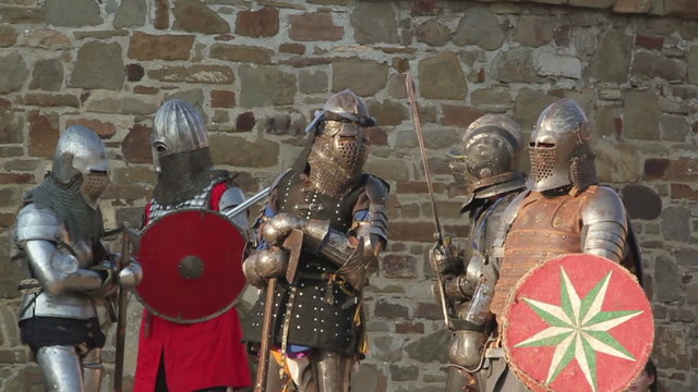 knights in armor stand in a fortress during the day
