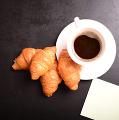 Breakfast with coffee, croissants and sticker for message.