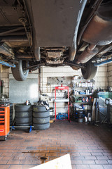 oldtimer auf hebebühne in alter kfz-werkstatt