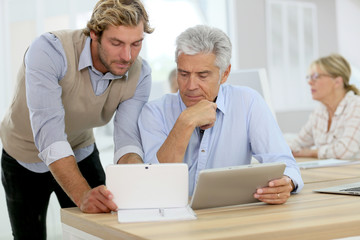 Senior man attending business class with trainer