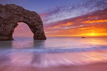 Durdle Door rock arch in Southern England at sunset - obrazy, fototapety, plakaty