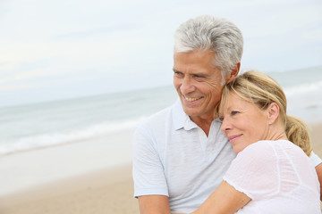 In love senior couple embracing at the beach