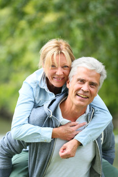 Senior man giving piggyback ride to his wife