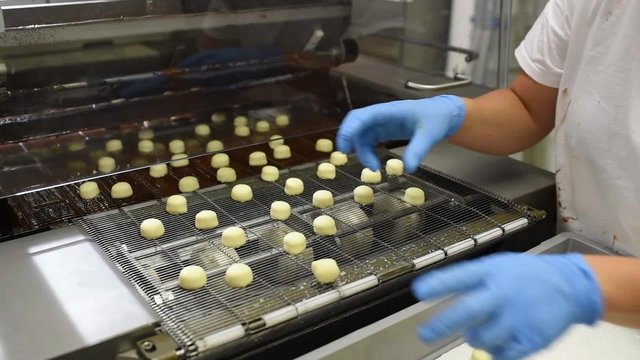 Fliessbandarbeit in der Lebensmittelindustrie - Herstellung von Pralinen in einer Fabrik // Conveyor working in the food industry - the production of chocolates in a factory