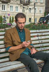 Obraz premium A young man sitting with cell phone
