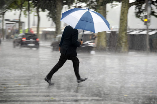 Running man with umbrella in the rain