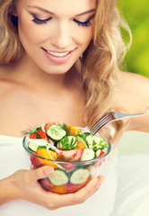 Woman eating salad, indoors