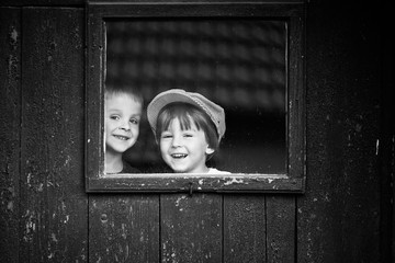 Two brothers on a window, talking and laughingm smiling at the c