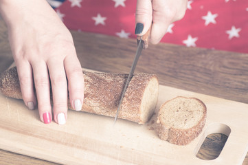Woman cuts bread on a cutting board