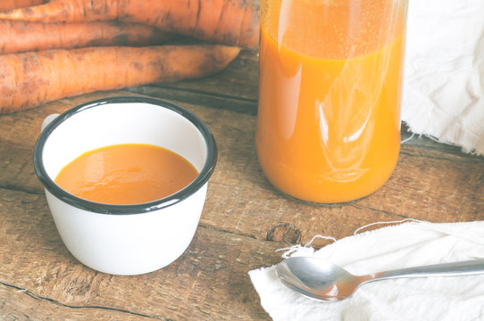 Carrot juice in a mug and a bottle