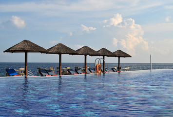 Swimming Pool with Sunchairs and Natural Umbrellas