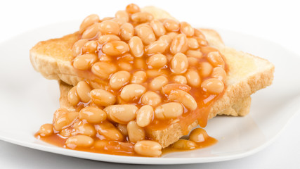 Beans on Toast - Slices of toasted white bread, buttered and topped with baked beans. Simple British breakfast meal.
