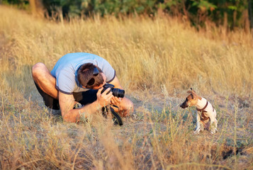 Photographer takes pictures of a small puppy in nature