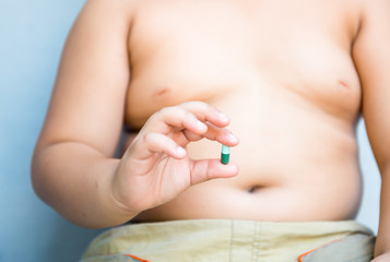 Fototapeta na wymiar Obesity pill in fat hand