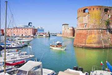 The Livorno's harbour with a ship sailing to the main Italian island - obrazy, fototapety, plakaty