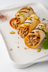 Sicilian cannoli with pistachio and mint  on the ceramic plate vertical