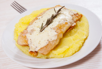 fish fillet under cheese with mashed potatoes