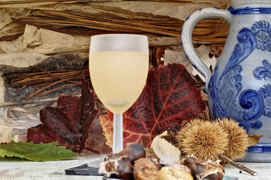 ein Glas mit neuem Wein und Esskastanien