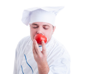 Cook or chef smelling fresh organic perfect red tomato