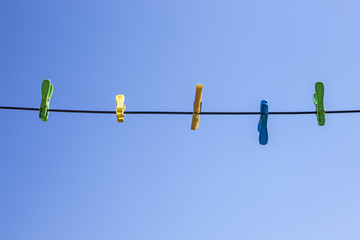 Clothespins on white rope and blue sky