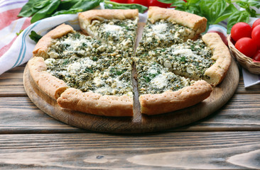Slices of open pie with spinach and tomato cherry on table close up